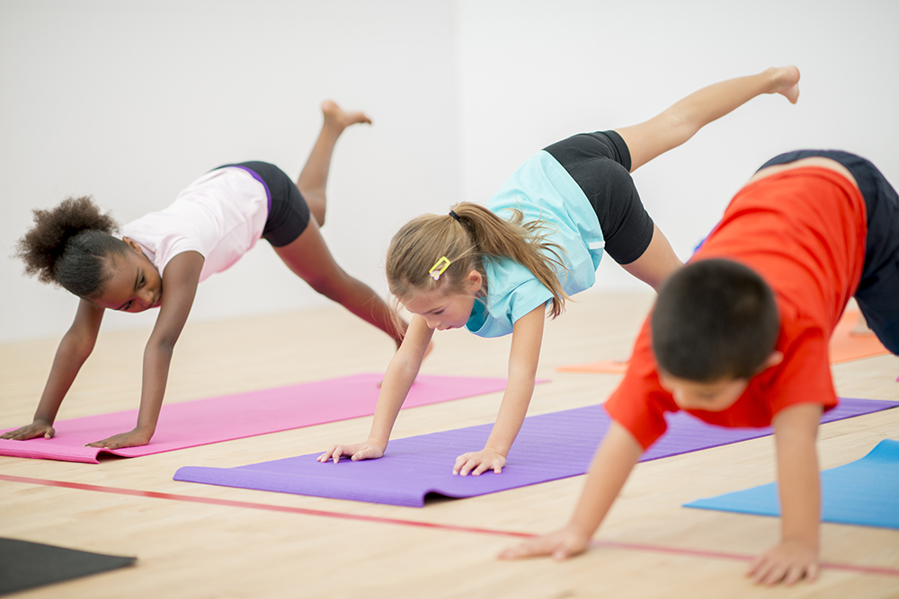children doing yoga on mats