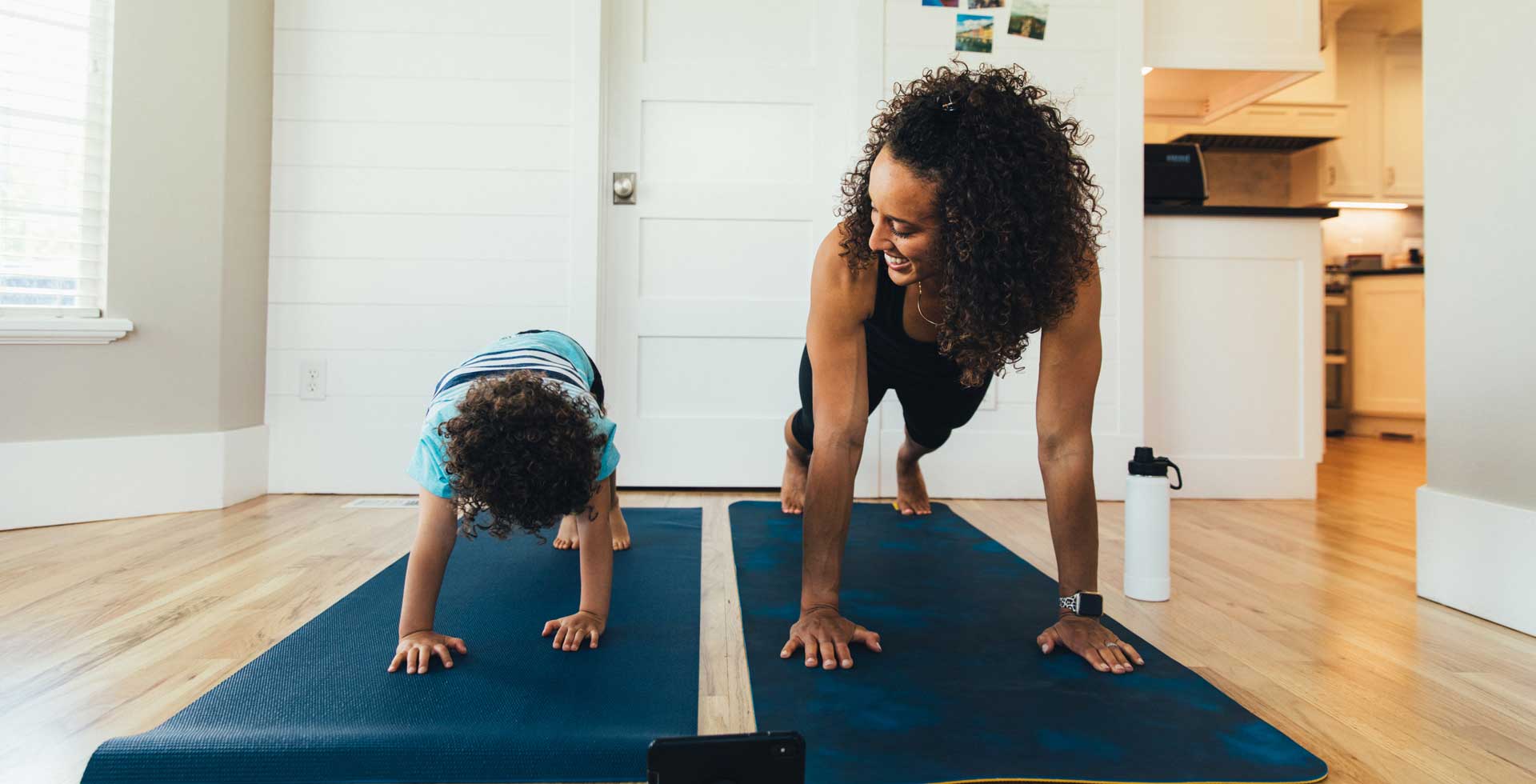 A mother and her young child do yoga together