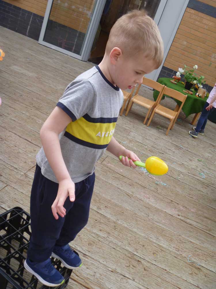 A preschool child carrying an egg on a spoon