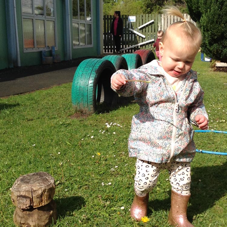 A toddler explores the nursery garden