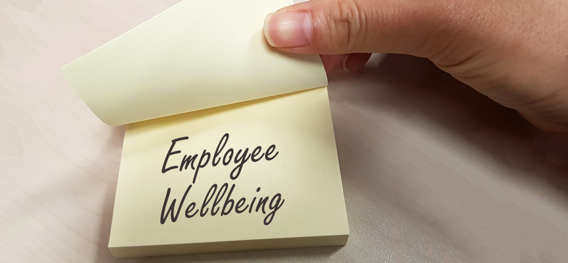 sticky note with employee wellbeing written on it