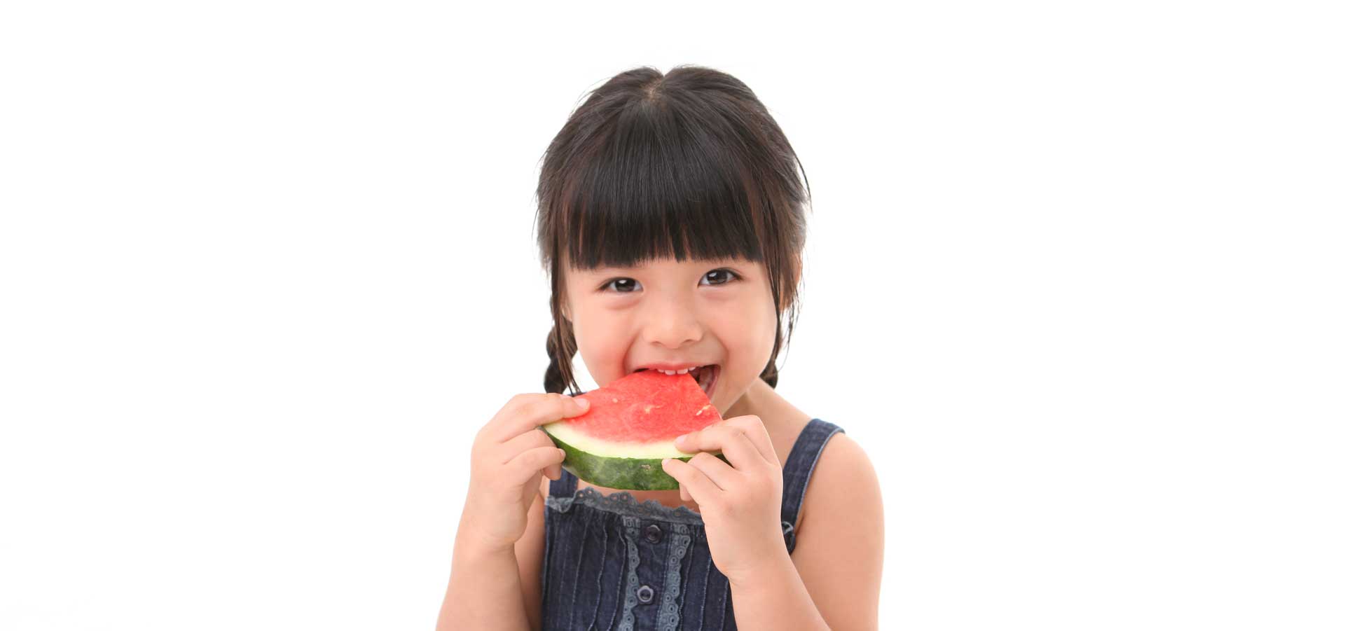 A young girl eating a slice of watermelon